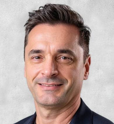 A headshot of Gerald Garcia with a gray background